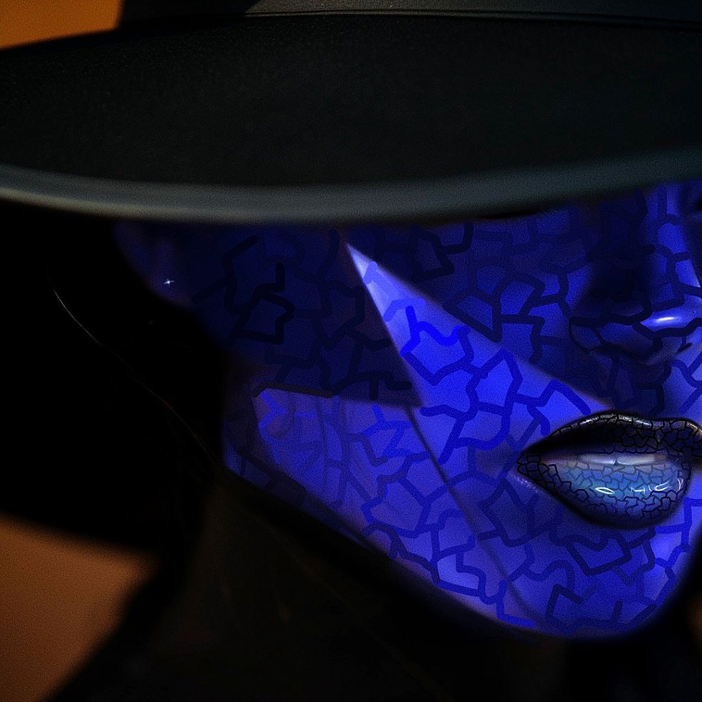 Lower face under wide hat, blue patterned skin